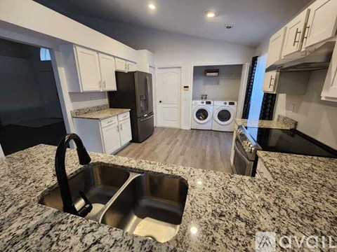 A kitchen with a granite countertop and stainless steel sink.
