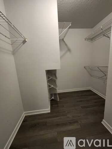 A room with a few shelves and a wooden floor.
