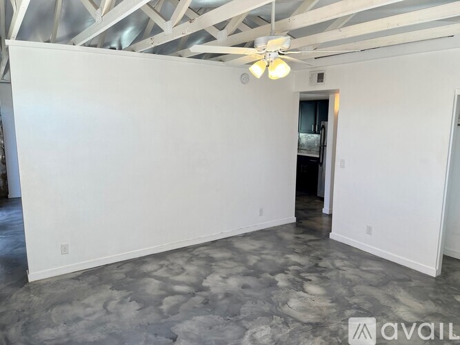 A spacious room with a ceiling fan and a marble floor.