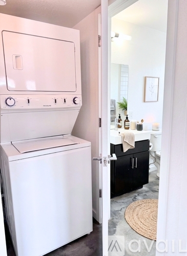 A white dishwasher is in a kitchen with a door open.
