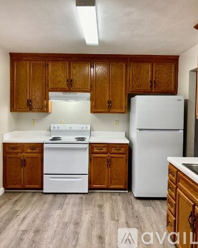 A kitchen with wooden cabinets and white appliances.