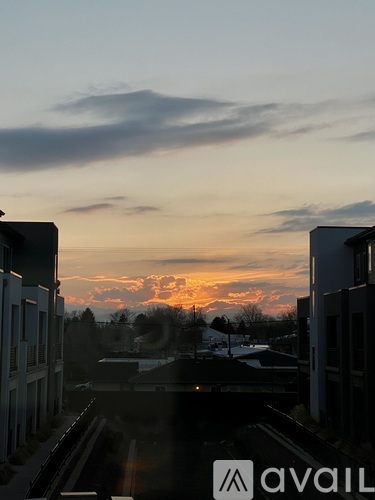 A sunset view from a window with buildings on either side.