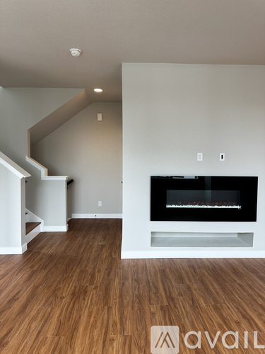 A living room with a fireplace and wooden floors.