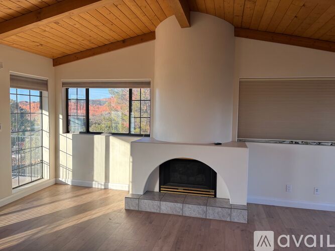 A living room with a fireplace and a large window.