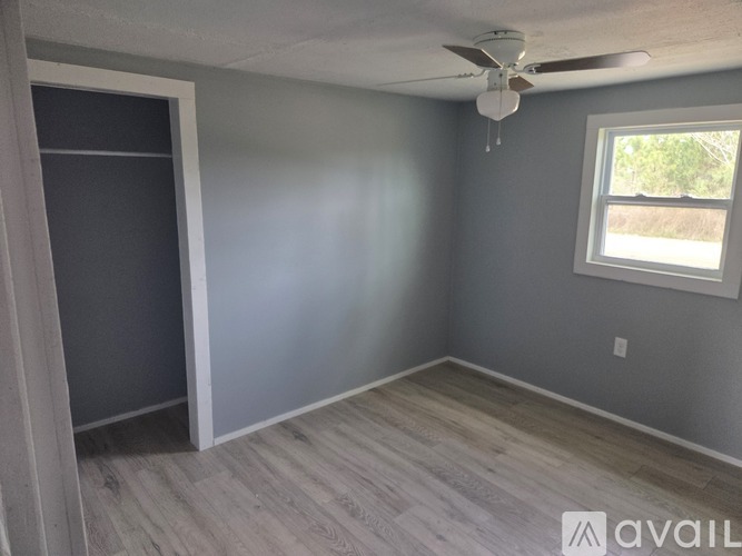 A room with a ceiling fan and a window.