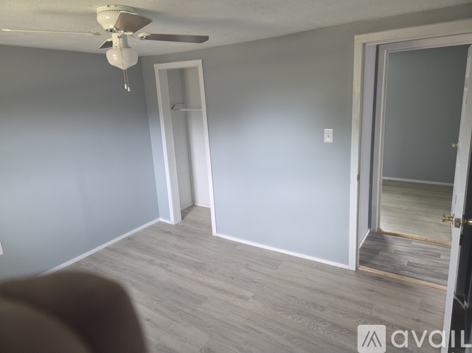 A room with a ceiling fan and light fixture.