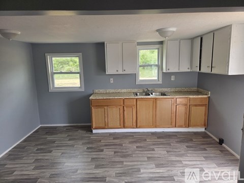 A kitchen with a wooden island and grey walls.