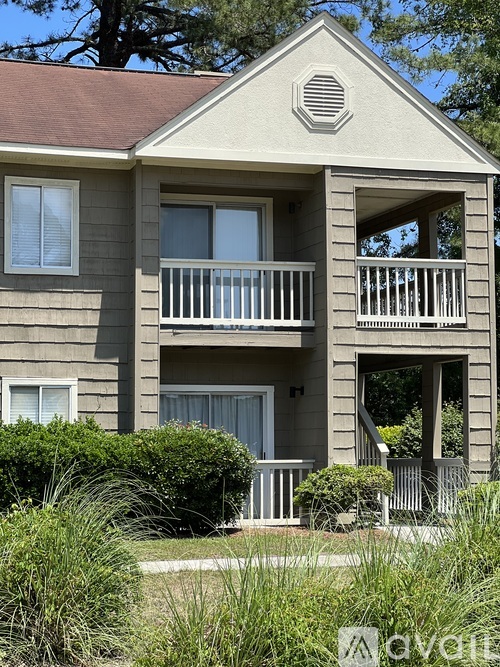 A two-story house with a balcony on the second floor.