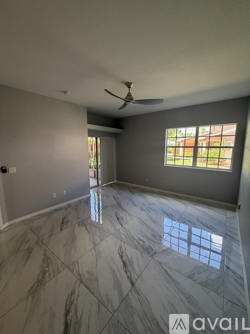 A room with a marble floor and a ceiling fan.
