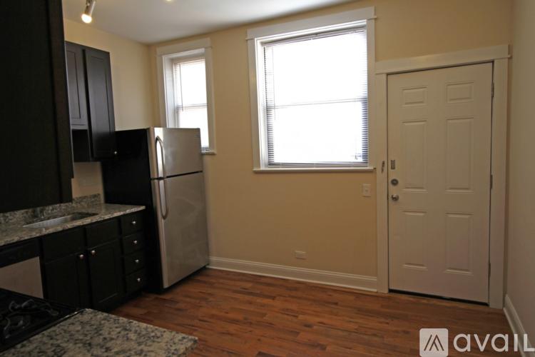 A kitchen with black cabinets and a granite countertop.
