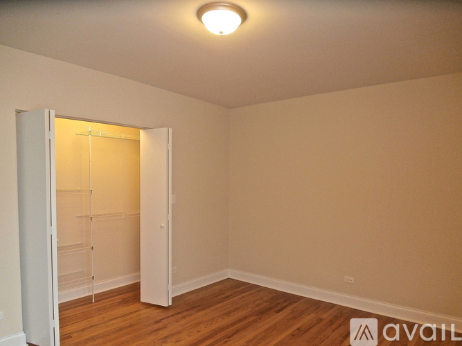 A room with a white door and a wooden floor.