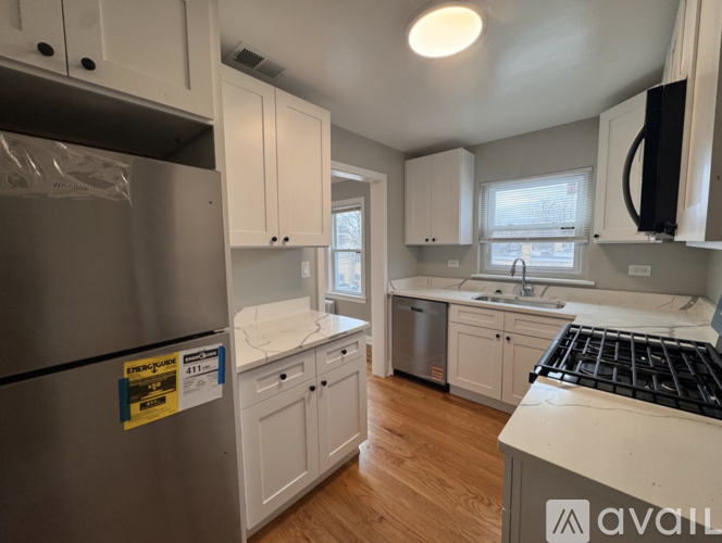 A kitchen with white cabinets and a stainless steel refrigerator.