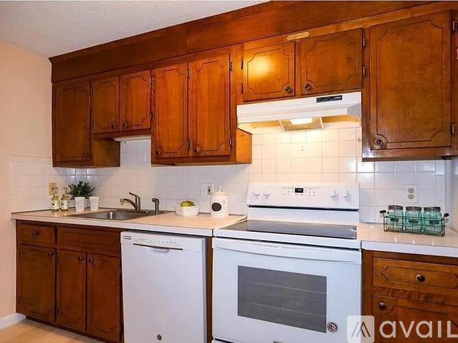 A kitchen with wooden cabinets and white appliances.