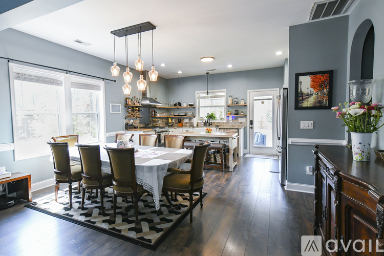 A dining room with a table set for six with a view of the trees outside the window.