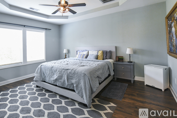 A bedroom with a bed, nightstand, and a ceiling fan.