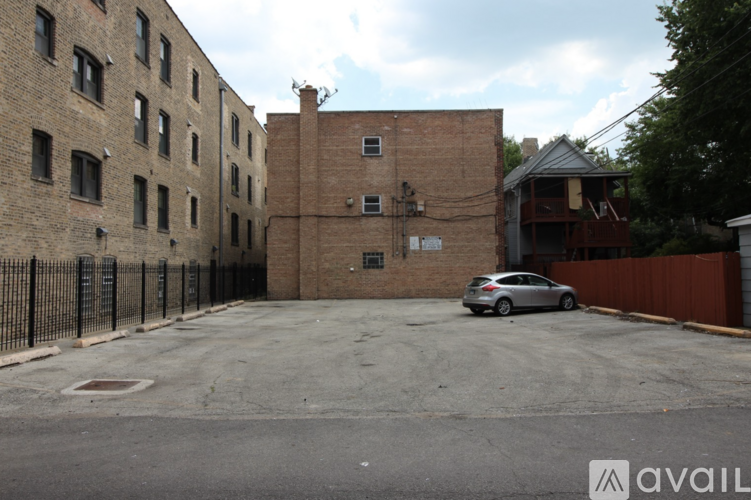 A parking lot with a car and a building in the background.