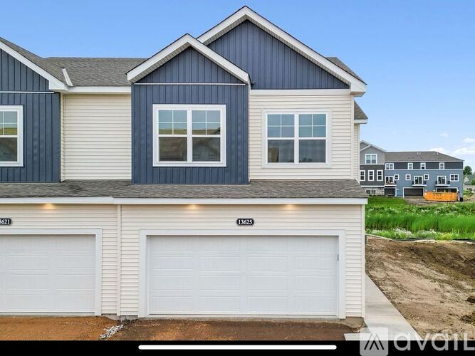 A blue house with white garage doors in front.