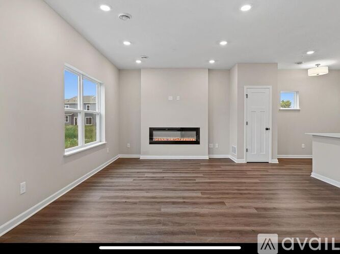 A spacious living room with a fireplace and hardwood floors.
