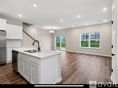 A kitchen with white cabinets and a wooden floor.