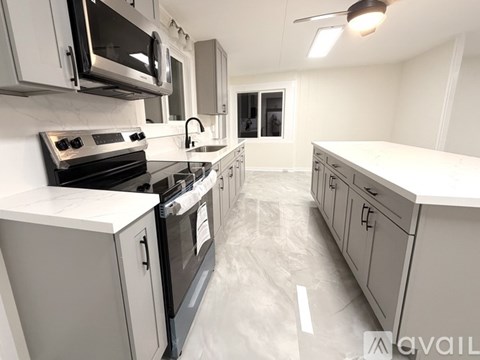 A kitchen with white cabinets and appliances.