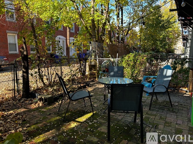 A patio with a table and chairs surrounded by trees.