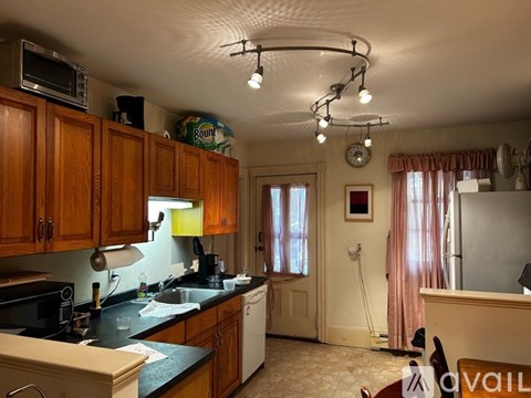 A kitchen with wooden cabinets and a black countertop.