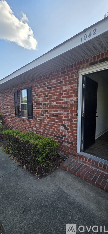 A brick house with a number 1042 on the top.