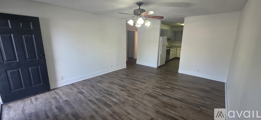 A room with a black door and wooden flooring.