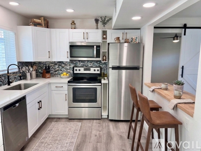 A modern kitchen with stainless steel appliances and white cabinets.