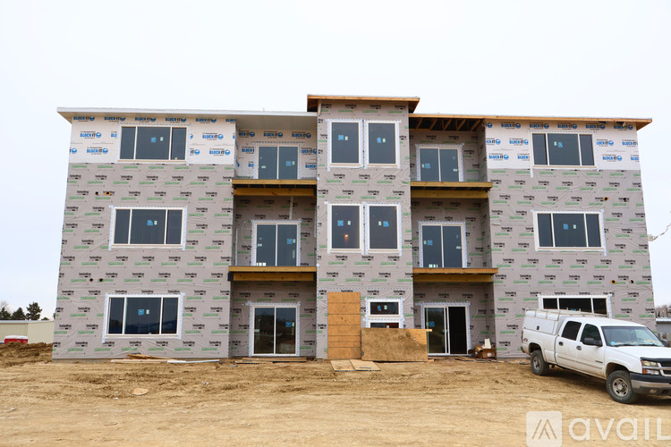 A building under construction with a white truck parked in front.