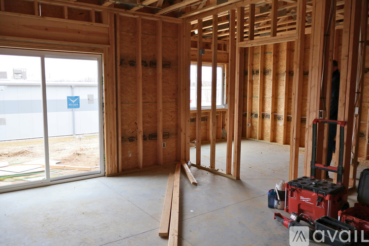 A room under construction with wooden framing and a window.