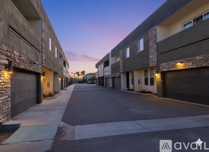 A street view of a residential area with buildings on either side and a clear sky.