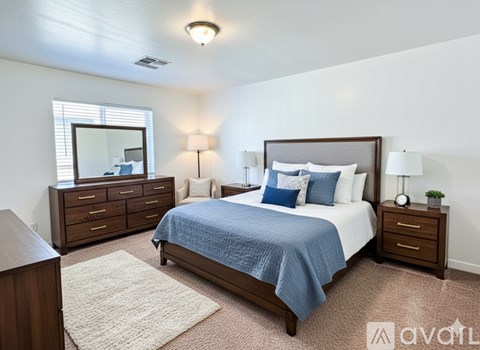 A bedroom with a bed, nightstand, and dresser.