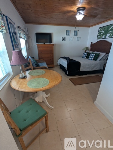 A bedroom with a bed, a chair, and a table.