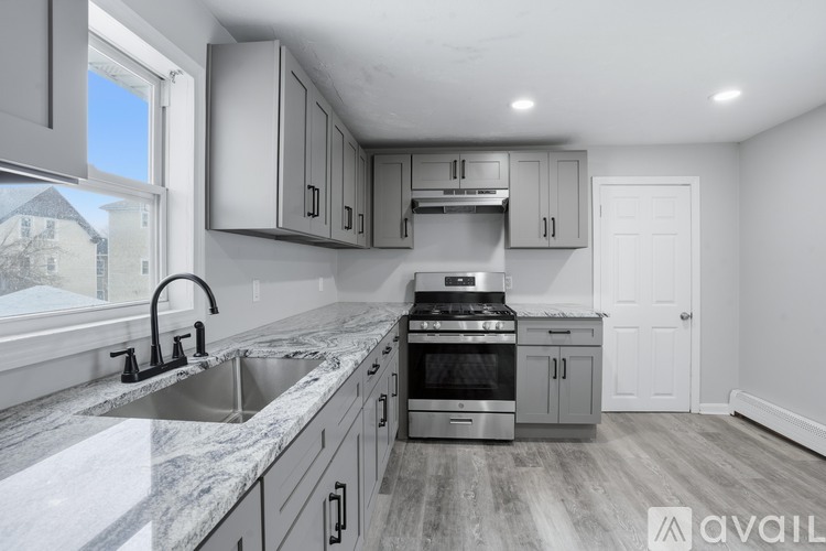A modern kitchen with stainless steel appliances and a marble countertop.