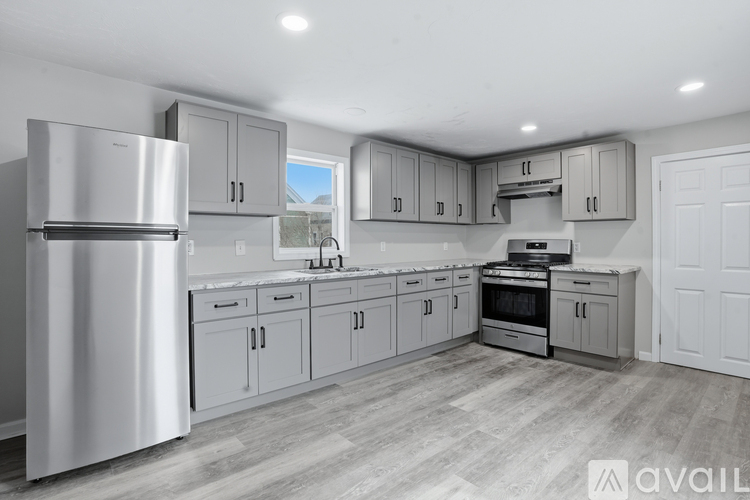 A modern kitchen with a refrigerator, sink, oven, and cabinets.