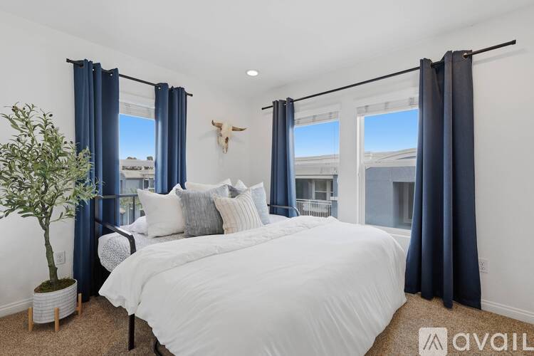A bedroom with a large bed and a cow skull on the wall.