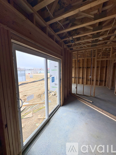 A room under construction with a view of the outdoors through a large window.