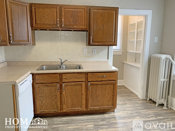A kitchen with wooden cabinets and a white dishwasher.