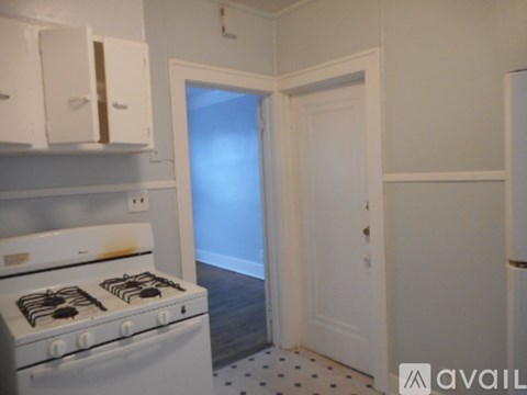 A white stove in a kitchen with a door in the background.