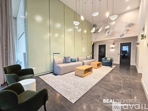 A living room with a grey rug and a green chair.
