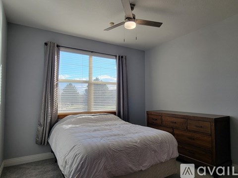 A bedroom with a bed, dresser, and window with blinds.