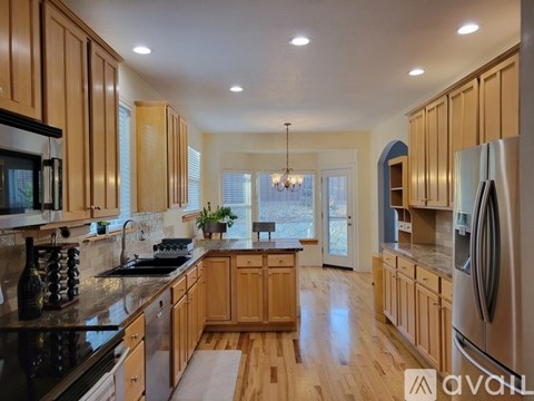 A modern kitchen with wooden cabinets and stainless steel appliances.