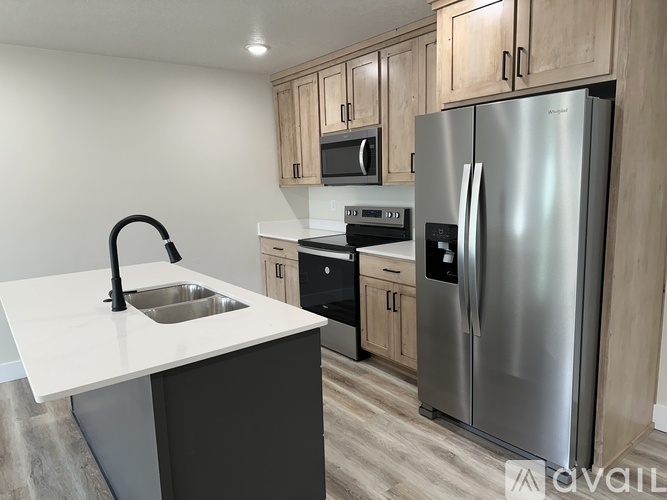 A modern kitchen with a stainless steel refrigerator, microwave, and oven.