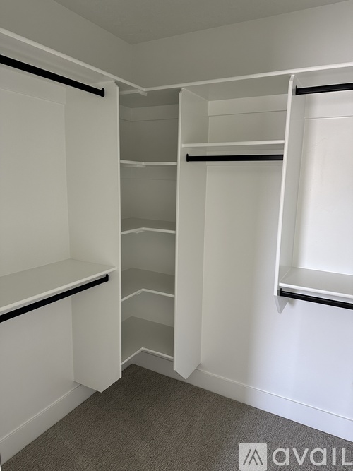 A white closet with shelves and hangers.