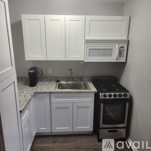 A kitchen with white cabinets and a black stove.