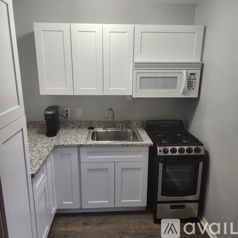 A kitchen with white cabinets and a black stove.