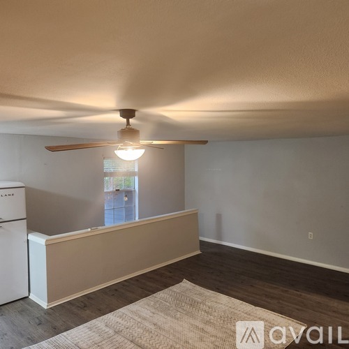A room with a ceiling fan and a window.