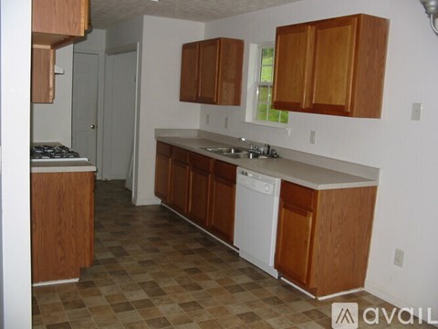 A kitchen with wooden cabinets and a checkered floor.