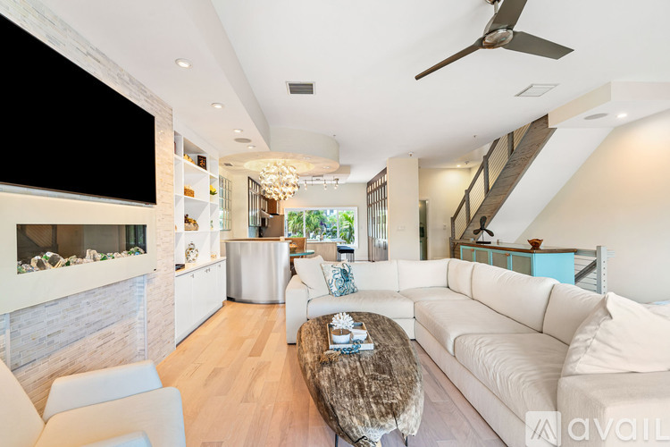 A living room with a white couch and a brown coffee table.